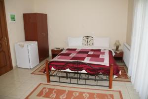 a bedroom with a bed with a red and white blanket at Elanthi Hostel kastoria in Kastoria