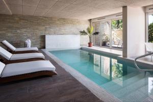 una piscina con 2 tumbonas en una casa en Costa Colonia - Riverside Boutique Hotel, en Colonia del Sacramento