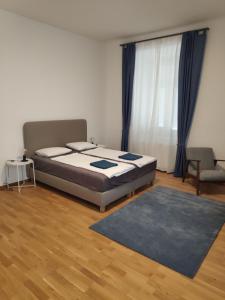 a bedroom with a bed and a couch and a window at Flataid Apartment Reitschulgasse - City Center - Jakominiplatz in Graz