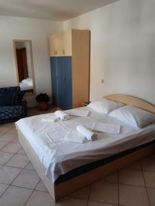 a large bed with white sheets and towels on it at House Vida Goraleks in Baška Voda