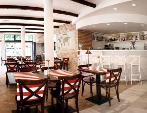 restauracja ze stołami i krzesłami oraz bar w obiekcie Apartamenty Mesa Grill Restaurant Cafe w Dźwirzynie