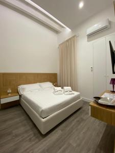 a bedroom with a large white bed and a desk at Star Suite in Taranto