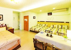 Cette chambre d'hôtel comprend deux lits, une table et des chaises. dans l'établissement Harmony Village, à Wujie