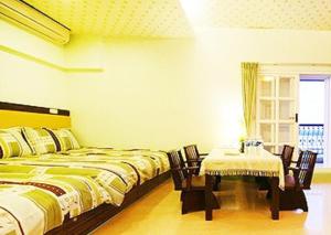 a bedroom with two beds and a table and a window at Harmony Village in Wujie