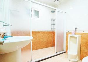 y baño con lavabo blanco y ducha. en Harmony Village, en Wujie