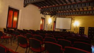 an empty room with chairs and a screen at Antica Dimora della Racchetta in Ferrara