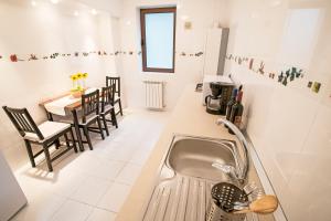 a kitchen with a sink and a table with chairs at 6 Apartments in Predeal +55 photos