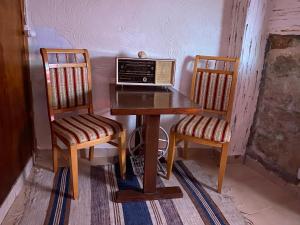 een houten tafel met twee stoelen en een magnetron erop bij Guest House Antique in Nazareth