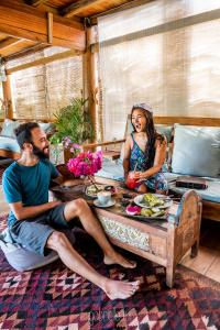 ギリ・アイルにあるFlowers & Fire Yoga Gardenの食卓に座る男女
