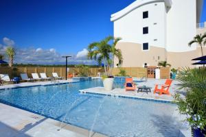Una piscina con sillas y un edificio. en Hotel Indigo Orange Beach - Gulf Shores by IHG, en Gulf Shores