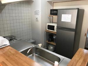 eine Küche mit einem Kühlschrank aus Edelstahl und einer Spüle in der Unterkunft Weekly Harbourview Mansion Main Building / Vacation STAY 76120 in Naha