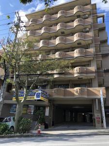 a large building with a parking garage in front of it at Weekly Harbourview Mansion Main Building / Vacation STAY 76120 in Naha