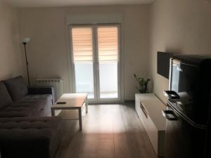 un soggiorno con un divano e una TV di Casa Leo a Teruel