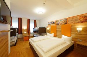 a bedroom with a large white bed in a room at Hotel zur Post in Leipheim