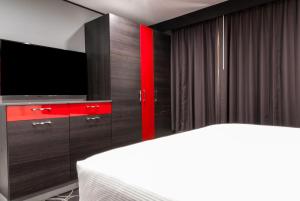 a bedroom with a tv and a red cabinet at Astro Pasadena Hotel in Pasadena