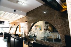 a lobby with a mirror and flowers on the wall at Lucape Palace Hotel in Barbacena