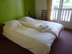 a white bed with towels on top of it at Chambres d'hôtes - Domaine de la Grangeotte in Labesserette