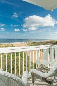 a balcony with two chairs and a view of the beach at The Saint Augustine Beach House in Saint Augustine