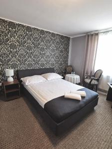 a bedroom with a bed with a black and white wallpaper at Pokoje gościnne Rubin in Zielona Góra