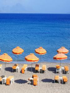 a group of chairs and umbrellas on a beach at Fantasia Hotel Apartments in Kos