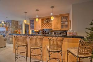 a kitchen with a bar with four stools at Fall River Hideaway in Estes - 3 Mi to Natl Park! in Estes Park +23 photos