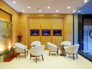 a waiting room with white chairs and tables at Elios Hotel in Ho Chi Minh City