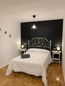 a bedroom with a large bed with a black wall at LOFT ESTUDIO CATEDRAL CASA LIS in Salamanca