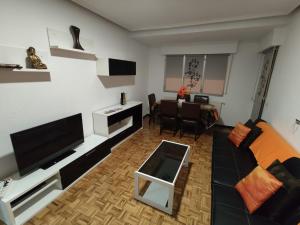 a living room with a black couch and a tv at Apartamento Cigüeña in Logroño