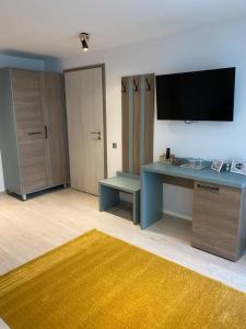 a living room with a desk and a tv on the wall at Adi&Nicol in Sibiu