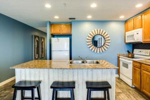 a kitchen with a sink and two bar stools at Sterling Reef 2 in Panama City Beach