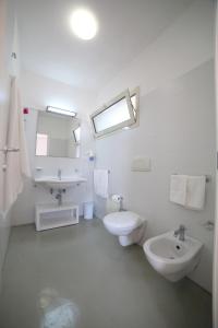 a white bathroom with a sink and a toilet at Hotel Beach Salento in Marina di Pescoluse