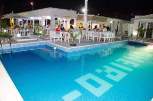a swimming pool with people sitting at a restaurant at Milan in Mamaia Nord