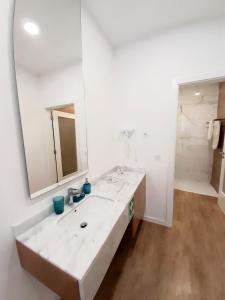 a white bathroom with a sink and a mirror at Residenza Dutzu - Aparthotel Leiria in Leiria