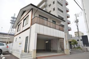 un gran edificio blanco con garaje en Takamatsu - House / Vacation STAY 38164 en Takamatsu