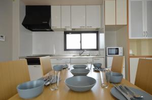 a kitchen with a wooden table with blue bowls on it at Takamatsu - House / Vacation STAY 38164 in Takamatsu