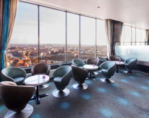 a waiting room with tables and chairs and large windows at Radisson Blu Hotel Lietuva in Vilnius