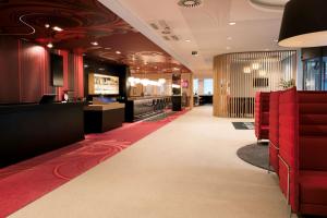 - un salon avec des chaises rouges et un tapis rouge dans l'établissement Hotel Park Inn by Radisson Brussels Midi, à Bruxelles