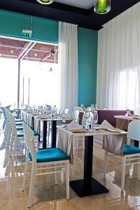a dining room with white tables and chairs at Park Inn by Radisson Hotel and Residence Duqm in Duqm