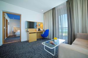 a room with a couch and a desk in a hotel room at Park Inn by Radisson Abu Dhabi Yas Island in Abu Dhabi