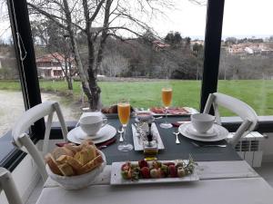 una mesa con desayuno de pan y zumo de naranja en Hotel Rural La Raposera, en Caravia