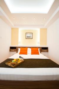 a large bed with a tray of fruit on it at 6 Apartments in Predeal