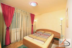 Schlafzimmer mit einem Bett mit roten Vorhängen und einem Fenster in der Unterkunft Apartament Ema Baile Felix in Baile Felix