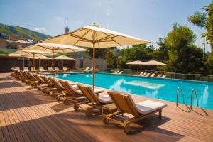 a row of chairs and umbrellas next to a swimming pool at Radisson Blu Iveria Hotel in Tbilisi City