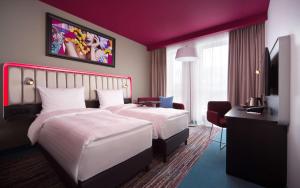 a hotel room with two beds and a flat screen tv at Park Inn by Radisson Riga Valdemara in Rīga
