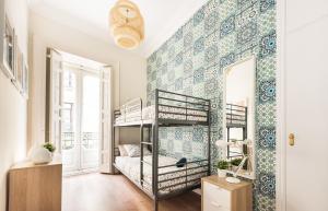 Un dormitorio con literas y una pared con azulejos azules y blancos. en Living Puerta del Sol, en Madrid