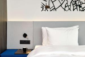 een slaapkamer met een bed met een witte sprei bij Radisson Blu Hotel, Bruges in Brugge