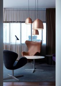 a room with a table and a chair and lamps at Radisson Collection Royal Hotel, Copenhagen in Copenhagen