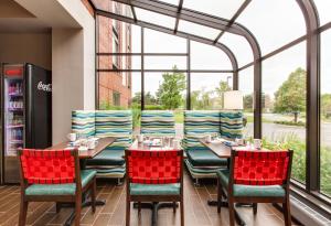 a restaurant with tables and chairs and a large window at Hotel Indigo Chicago - Vernon Hills, an IHG Hotel in Vernon Hills