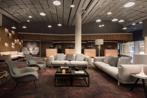 Un vestíbulo con sofás y sillas y una mesa. en Radisson Blu Scandinavia Hotel, Oslo, en Oslo 215 fotos más