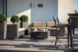 a patio with a couch and a table and chairs at Radisson Blu Hotel, Hamburg Airport in Hamburg
